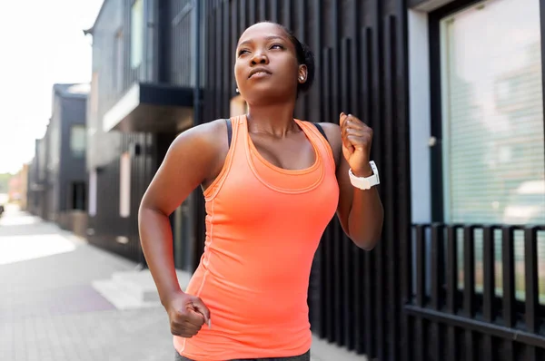 Genç Afrikalı Amerikalı kadın şehirde koşuyor. — Stok fotoğraf