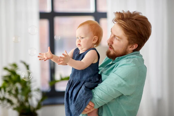 Padre E Hija Bebe Con Burbujas De Jabon En Casa Jugando Cabello Rojo Stock Photo Padre E Hija Bebe Con Burbujas De Jabon En Casa Jugando Cabello Rojo Stock Photo