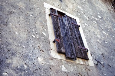 Antika ahşap kepenkleri eski bir evin duvarında penceresiyle.