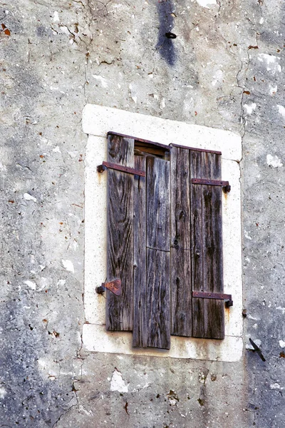 Antieke venster met houten luiken in de muur — Stockfoto