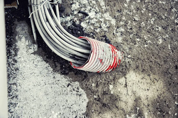 Un gran conjunto de cables fuera del agujero en la tubería —  Fotos de Stock