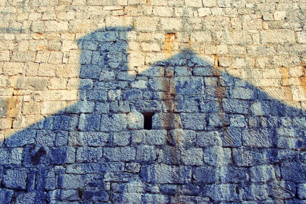 Huis schaduw op een oude stenen muur — Stockfoto