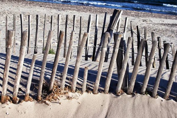 Cercas de madeira desgastadas à beira-mar na praia de areia — Fotografia de Stock