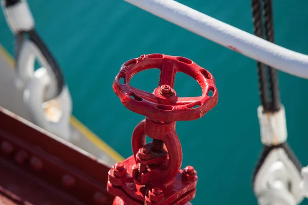 Válvula giratoria roja contra fondo azul de agua de mar —  Fotos de Stock