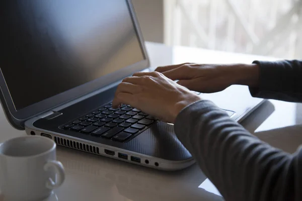 Jovem mulher está trabalhando em seu laptop — Fotografia de Stock