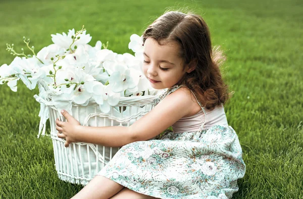 抱着一篮子鲜花的甜美的小女孩 — 图库照片