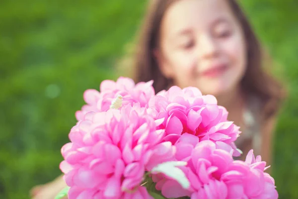 美丽的小女孩捧着一束五颜六色的花朵 — 图库照片