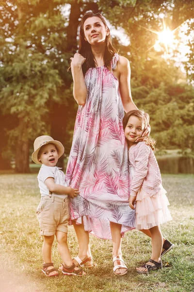 Entzückende Und Fröhliche Kinder Die Die Beine Ihrer Mutter Halten — Stockfoto