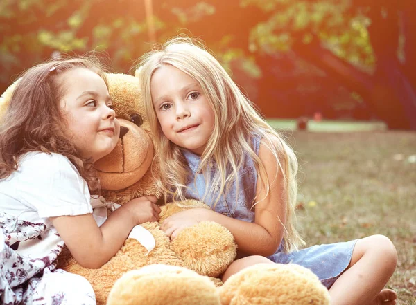 Twee Leuke Meisjes Knuffelen Van Een Grote Nieuwe Teddybeer — Stockfoto