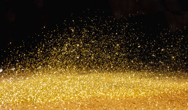 Golden, shining powder scattered over the dark background