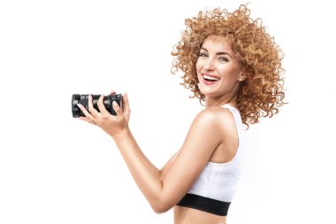 Commercial style portrait of a redhead, frizzy-haired woman holding a camera clipart