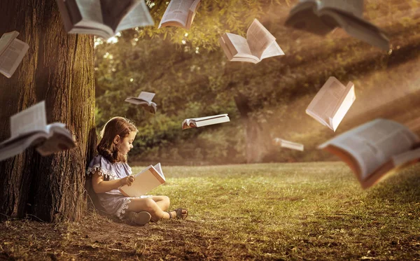 快乐的孩子在夏日公园里读一本有趣的书 — 图库照片