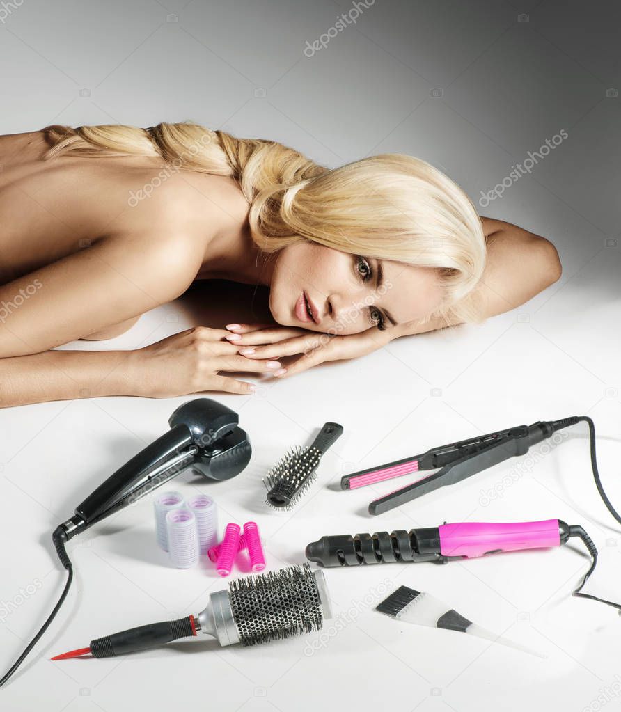 Blond woman lying and looking at the bathroom devices