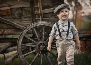 Portre og küçük, şirin centilmen bir ahşap vagon üzerinde poz
