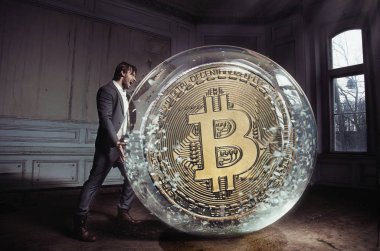 Kavramsal bir bitcoin taşıyan bir yakışıklı, şık işadamı portresi 