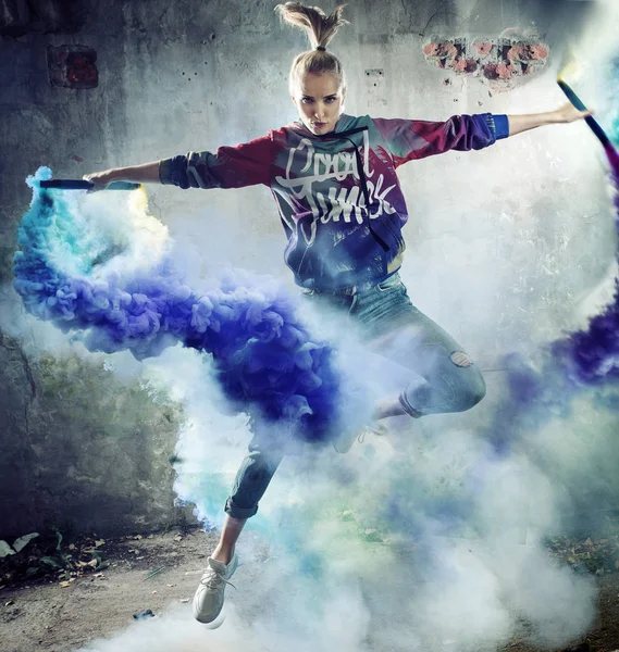 一个跳跃的女孩舞蹈家拿着五颜六色的耀斑的画像 — 图库照片