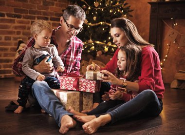 Cheerful, realxed family unboxing presents together clipart