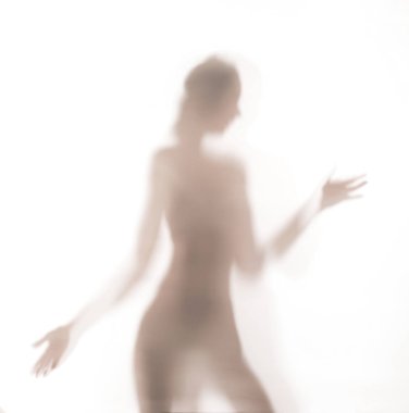 Bir cam kapının arkasında dans kadın silüeti