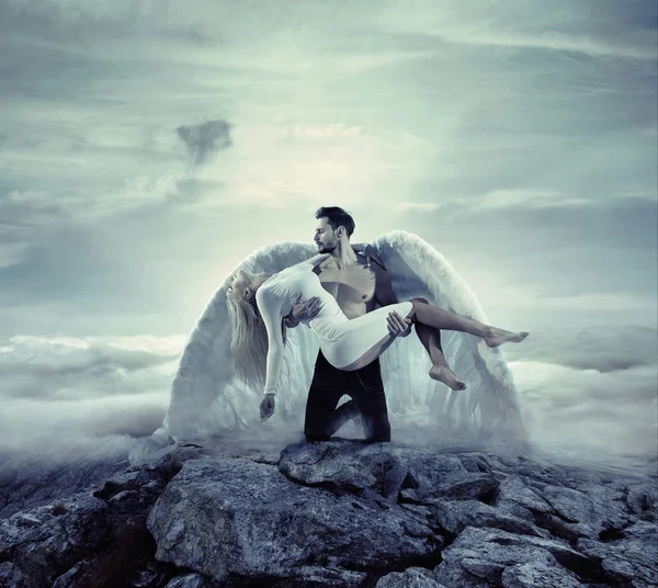 罪のない、無意識の女性を運ぶハンサムな大天使 — ストック写真