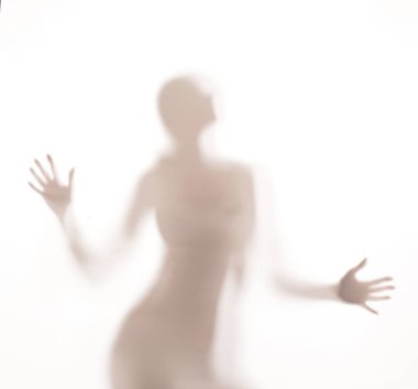 Cam kapının arkasında dans eden kadın silueti