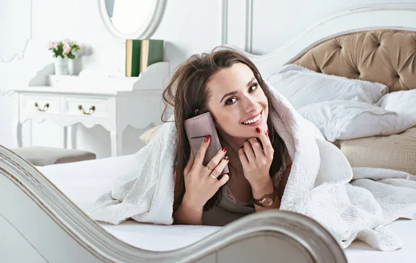 Relaxte dame in bed liggen en praten over de telefoon — Stockfoto
