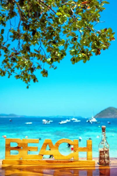 Wooden inscription "beach" and calm ocean in the background — 스톡 사진