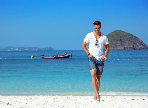 Bonito, homem musculoso relaxante em uma praia tropical — Fotografia de Stock