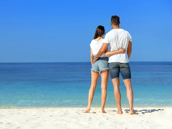 Jeune, beau couple relaxant sur une plage tropicale — Photo