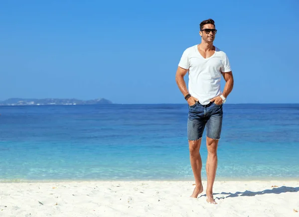 Beau, homme musclé se relaxant sur une plage tropicale — Photo