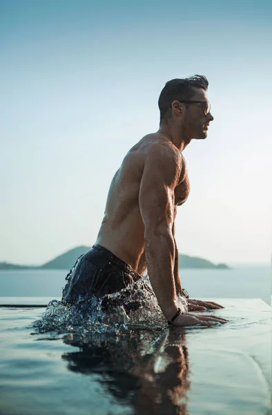 Ritratto di un uomo serio in una piscina tropicale — Foto Stock