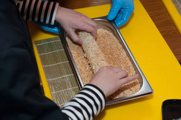 Men\'s hands and children hands that make sushi in the cafe