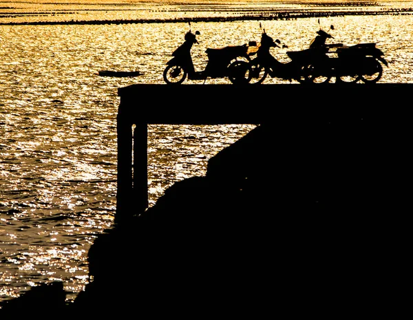 Silhueta Motocicletas Doca Com Efeito Luz Pôr Sol Superfície Mar — Fotografia de Stock