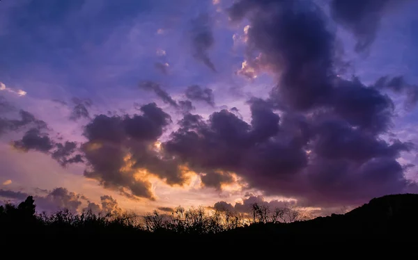 Nice twilight sky with silhouette of field and hill background