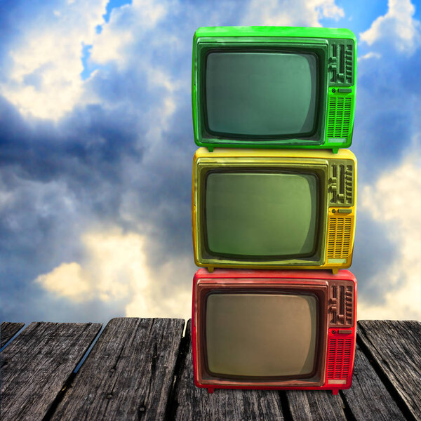 Retro television overlap on wooden deck with clouds sky background
