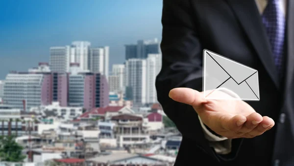 Contáctenos concepto, Empresario llevar correo electrónico en la mano con citysca —  Fotos de Stock