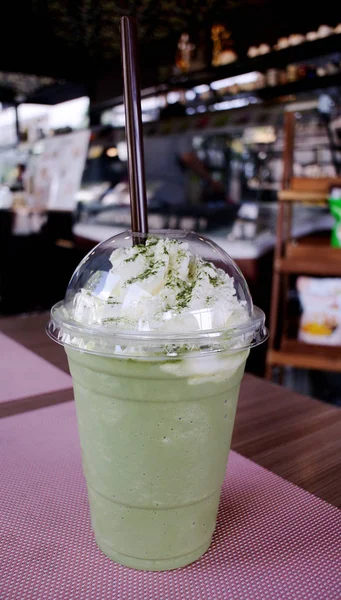 Grönt te frappe med piska grädde på bord — Stockfoto