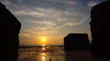 Günbatımı beton blok ön plan silueti ile zaman atlamalı Beach