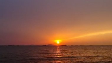 Kargo gemisi silüeti ile denizde günbatımı zaman atlamalı