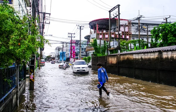 Niezidentyfikowany człowiek chodzić po powodzi po deszczu w Sriracha c — Zdjęcie stockowe