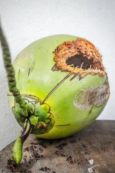 Groene kokosnoot met gat op tafel — Stockfoto