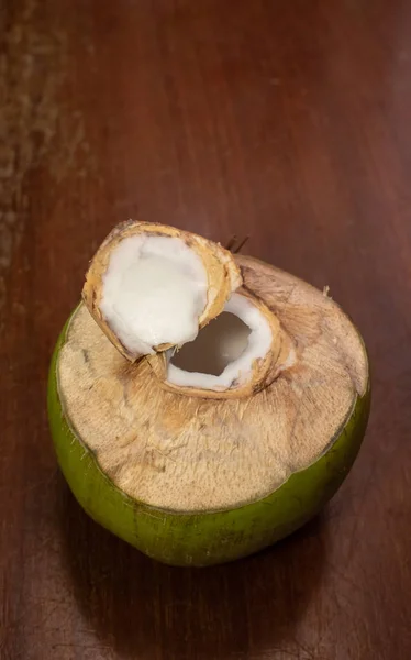 Fruta de coco aberta sobre mesa de madeira — Fotografia de Stock