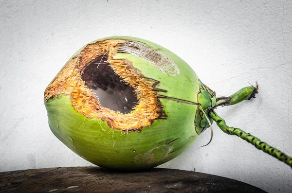 Groene kokosnoot met gat op tafel — Stockfoto