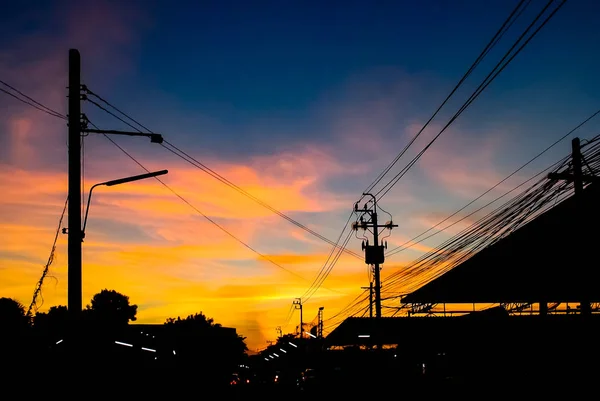 Cielo dramático con silueta de poste de electricidad y alambre — Foto de Stock