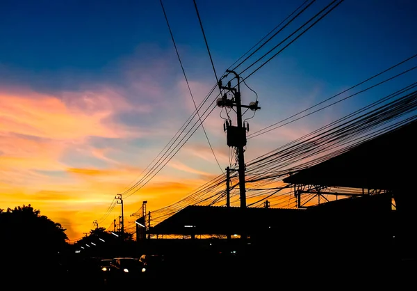 Dramatische hemel met silhouet van elektriciteitspaal en draad — Stockfoto