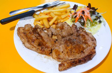 Salata ve kızarmış patates ile domuz biftek