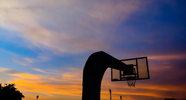 Silhouette del cerchio da basket con cielo drammatico — Foto Stock