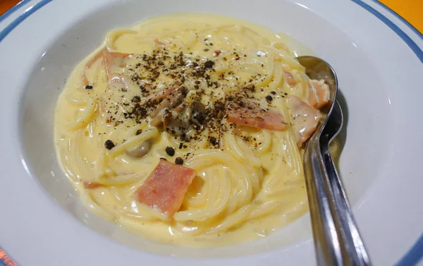 Espaguetis carbonara con pimienta en plato blanco —  Fotos de Stock