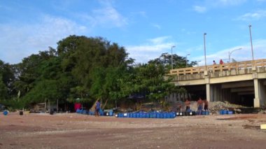 Chonburi, Tayland - 26 Temmuz: Bir grup adam 26 Temmuz 2019 tarihinde Tayland 'ın Chonburi kentinde yeşil midye çiftliği için bağlı mavi tankı taşıdı