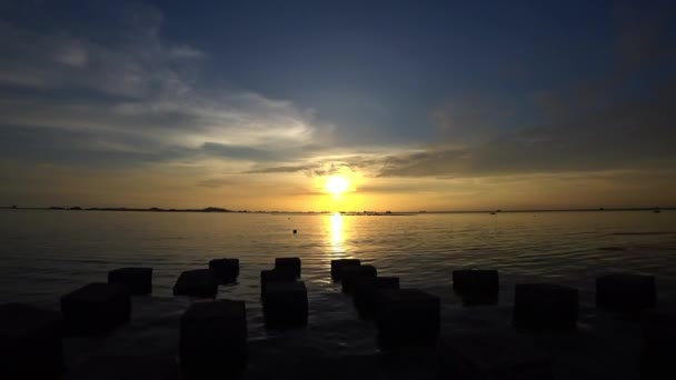Solnedgång till havs med betongblock förgrund — Stockvideo