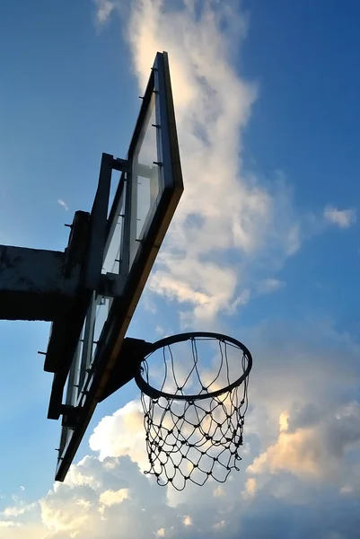 Silhouet van oude basketbalring met wolken in de avondlucht — Stockfoto